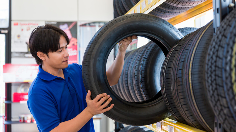 A person pulling a tire off the rack.