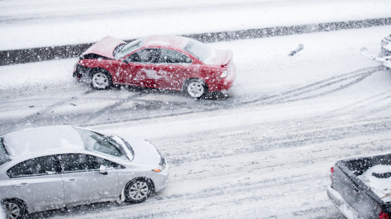 Cars driving and sliding on snowy road