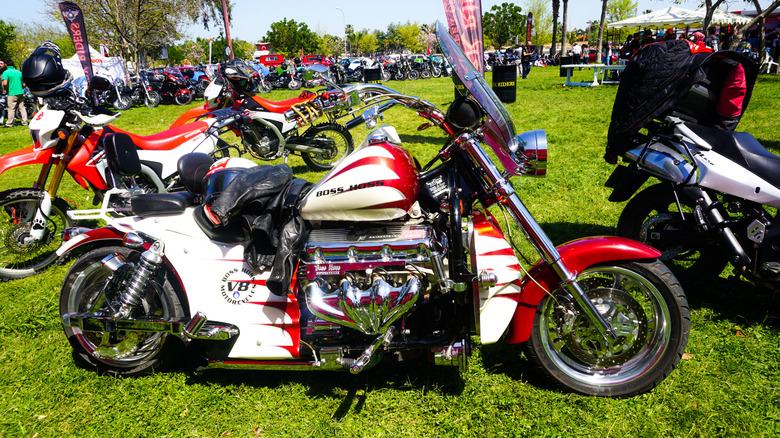 A white and red Boss Hoss Motorcycle V8 at a crowded show on a sunny day