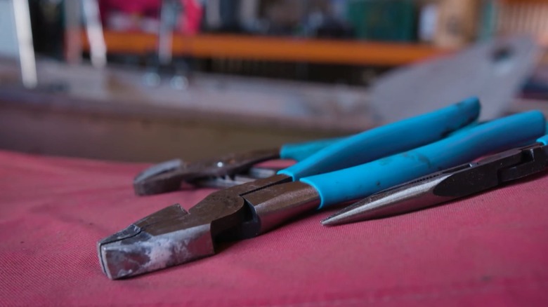 Chanellock pliers on a red cloth surface