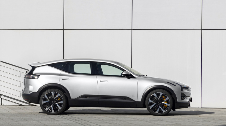 Side shot of a silver Polestar 3 in front of a building