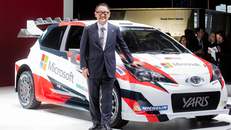 Akio Toyoda in front of Toyota Yaris World Rally Championship car