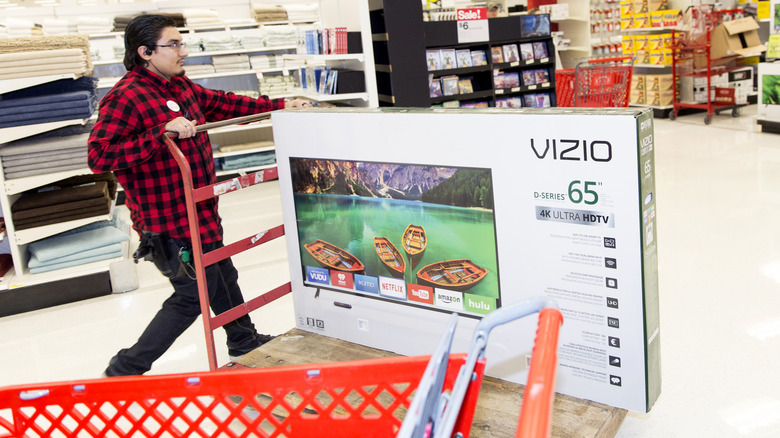 Person with a Vizio TV on a cart.