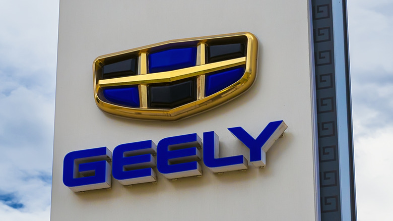 Geely logo on dealership sign with cloudy sky in background