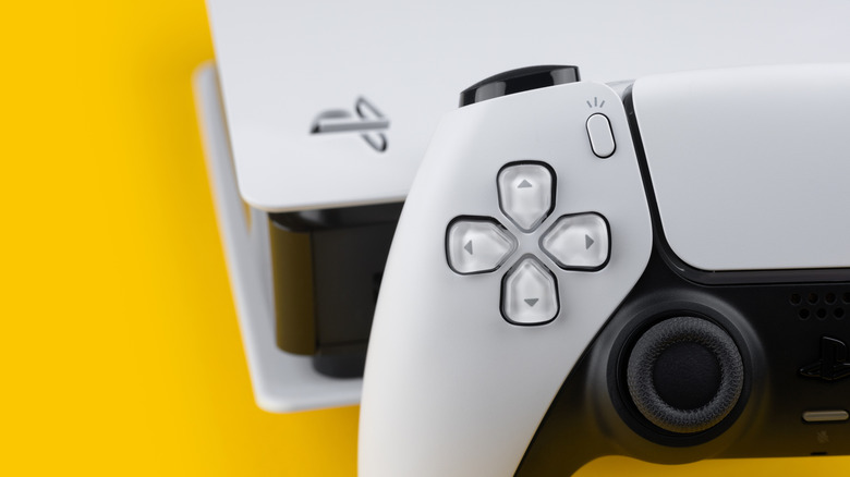 PlayStation 5 and controller against yellow background