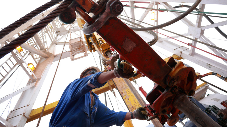 operator in blue uniform working machinery in an oil rig