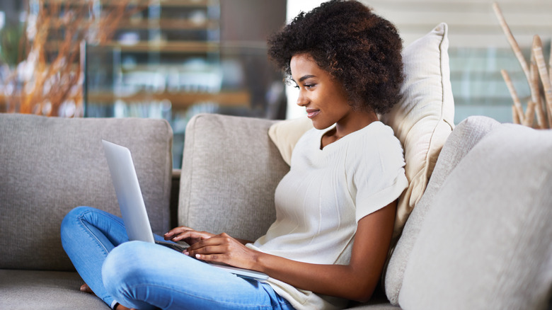 woman using laptop on couch