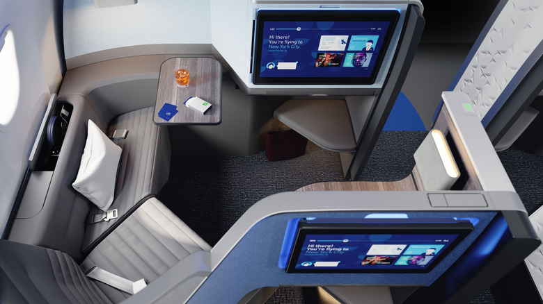 A seat in JetBlue first class with a large in-flight screen.