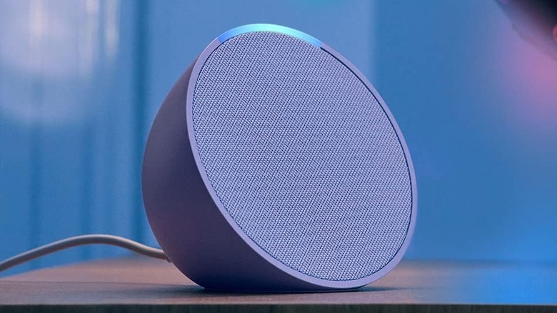 a lavender colored Amazon Echo Pop sitting on a side table