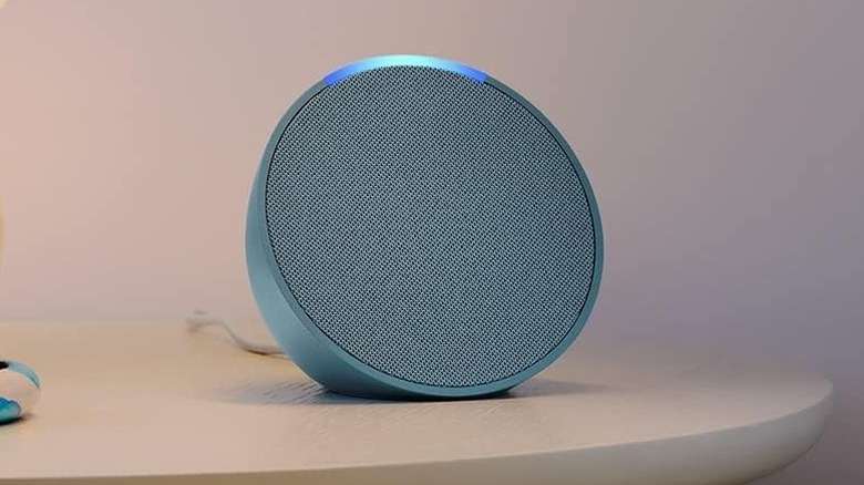 teal Amazon Echo Pop sitting on a side table