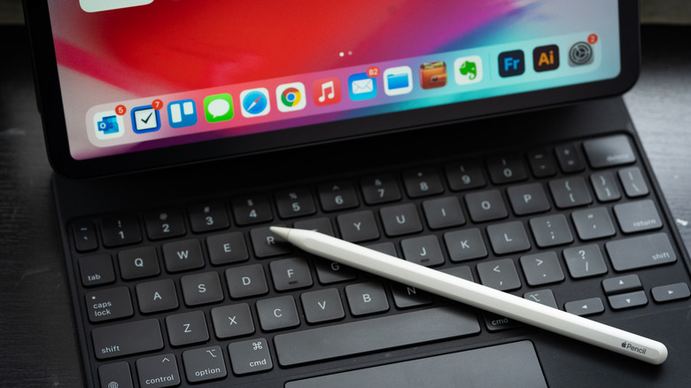 An Apple Pencil placed over an iPad's keyboard.