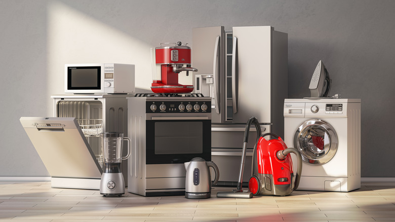 set of home kitchen appliances like a dish wahser, oven, vacuum cleaner, washer, and refrigerator, placed on the floor inside a room