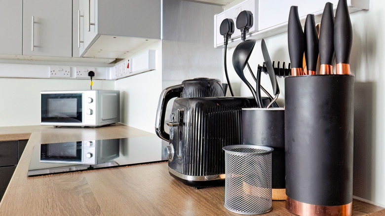 toaster, electric kettle, and microwave placed on a kitchen counter alongside other items