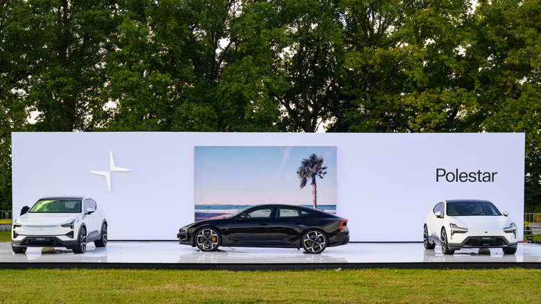 The Polestar 4 and polestar 5 sedans on display on a podium at a car show.