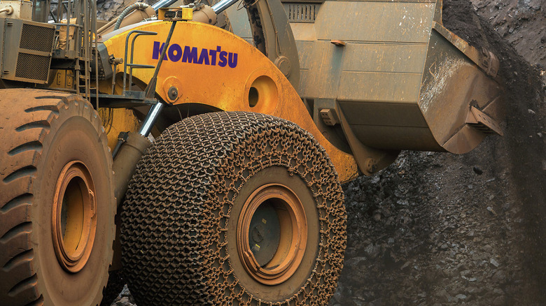 Close-up of Firestone 70/70x57 tires fitted to a Komatsu 2350 loader, the tires are fitted with chains.