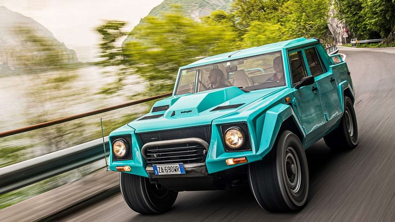 A Lamborghini LM002 driving along a country road, front-left view