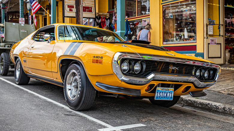 Front 3/4 view of yellow 1971 Plymouth GTX parked on street.