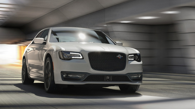 Front view of white 2023 Chrysler 300C driving in tunnel.