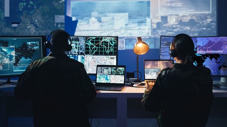 Security, satellite map and man with woman at monitor in army office at command center