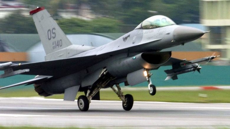an f-16 fighting falcon takes off from a military base
