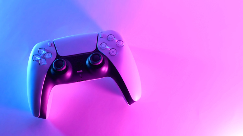 A PS5 controller against a pink and blue gradient background