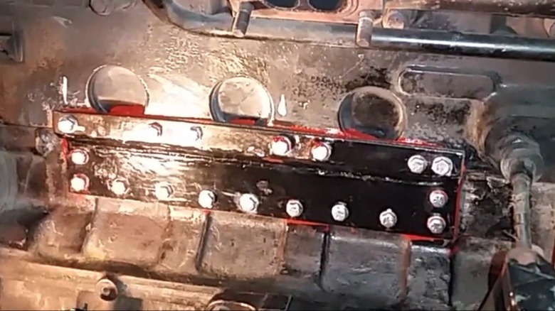 A cracked Cummins 53 block repaired with J-B Weld and a bolted plate.