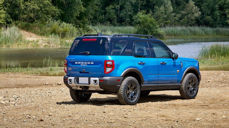 Rear 3/4 view of blue 2025 Ford Bronco Sport parked on dirt