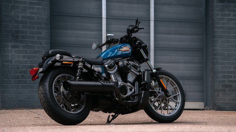 A side shot of a blue Harley-Davidson Nightster parked in front of a garage.