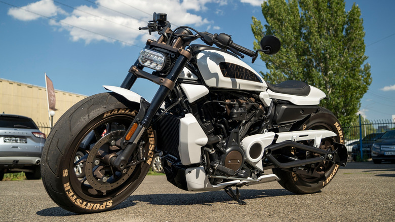 A low angle shot of a white Harley-Davidson Sportster S in a parking lot.