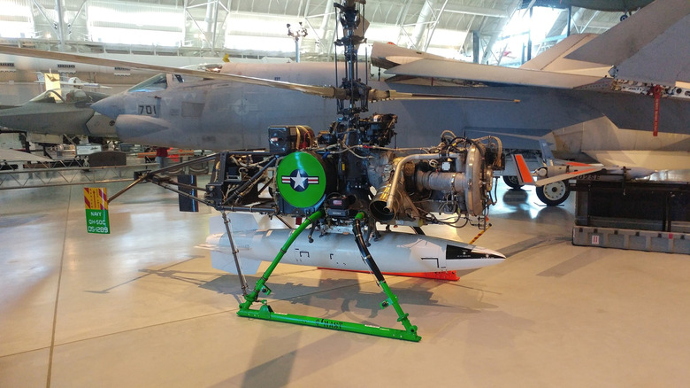 A green and black Gyrodyne QH-50C (DSN-3) drone helicopter at a aircraft hangar