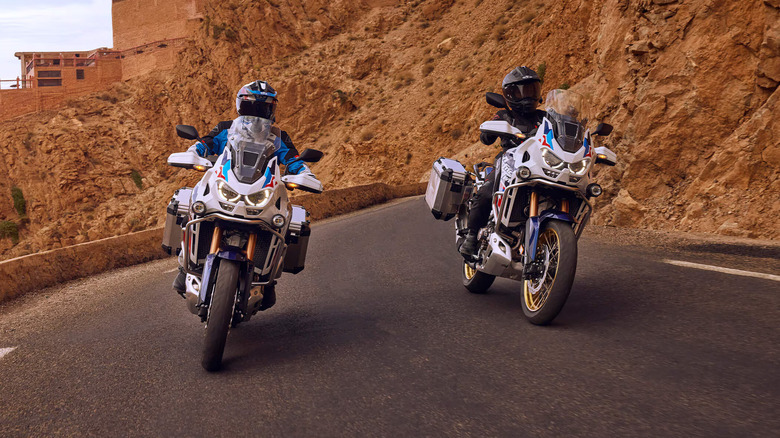 Two white 2024 Honda Africa Twins cornering on tarmac