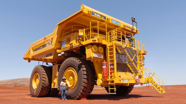 Person standing next to a large Komatsu mining truck