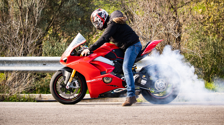 Man on a Ducati Panigale V4 doing a burnout, side view