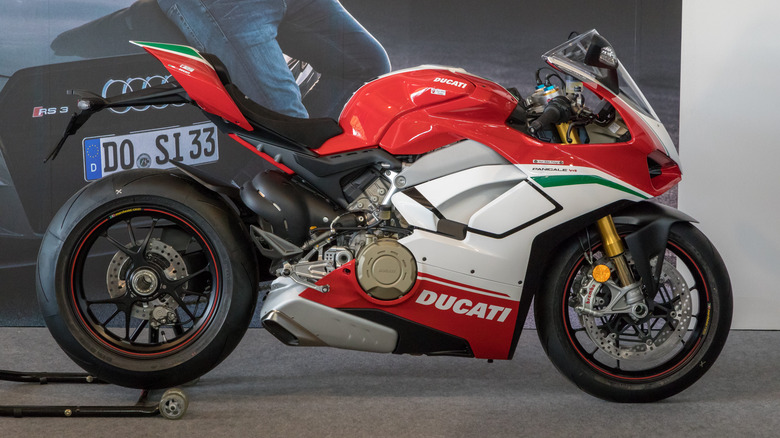 A two-tone red and white Ducati Panigale V4 on display, side view