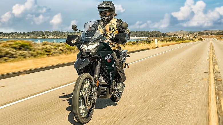 Person riding a Kawasaki KLR 650, which features a 6.1 gallon gas tank