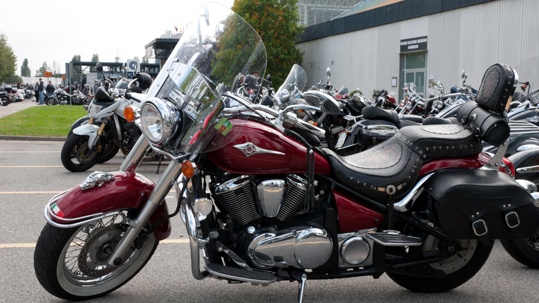 A side view of a red and black Kawasaki Vulcan 900 Classic LT parked on a gloomy day