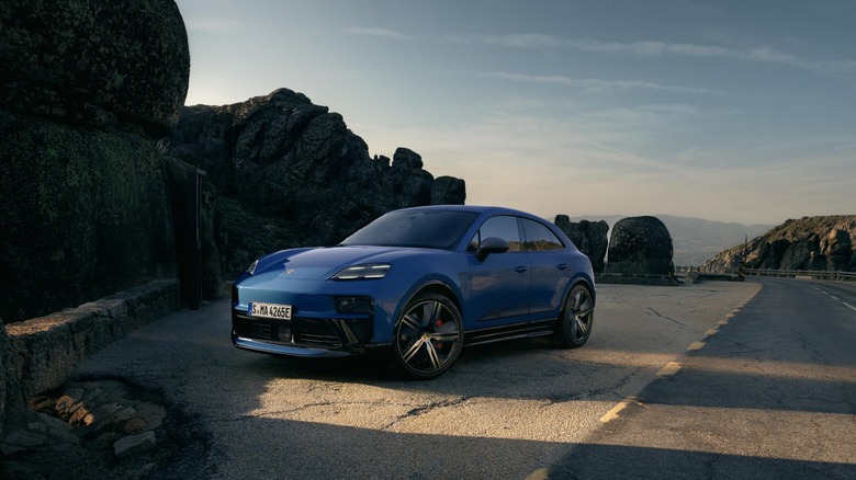 Blue Porsche Macan GTS parked at the side of a road with rocks in the background