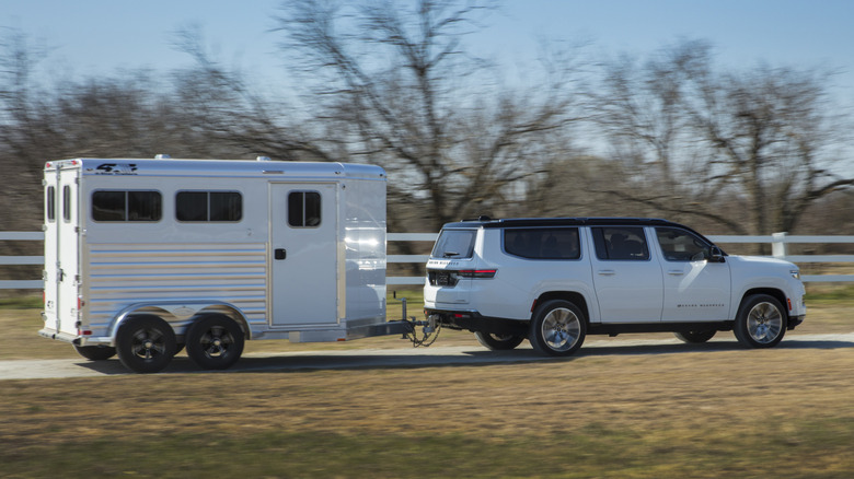 Side profile dynamic shot of a white 2025 Jeep Wagoneer towing.