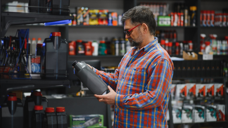 Man looking at motor oil container
