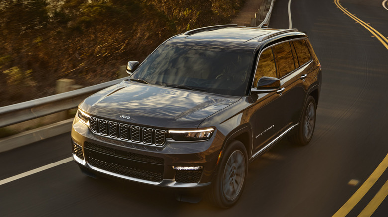 Front 3/4 view of Jeep Grand Cherokee L on winding road in wooded area