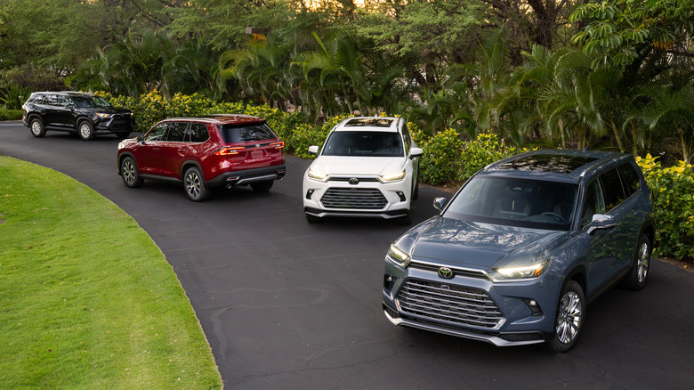 Aerial view of several Toyota Grand Highlanders parked in different positions on a road in a wooded area