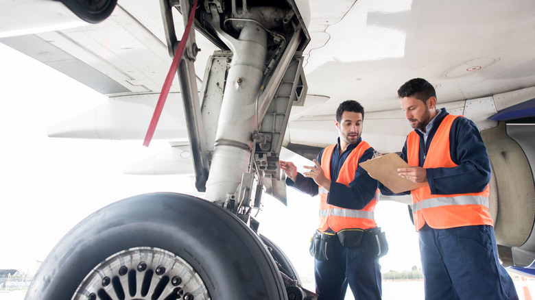 aircraft maintenance technicians examining landing gear