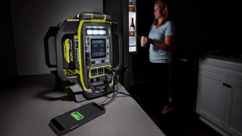 Woman using inverter to charge phone and fridge