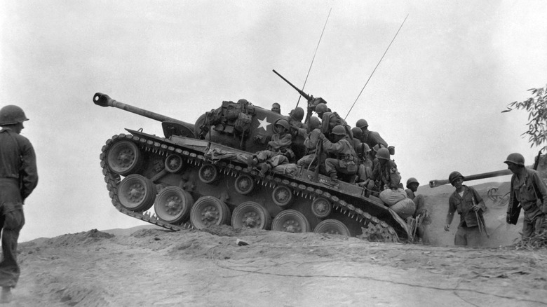 U.S. Soldiers atop an M26 Pershing tank as they wait to engage the enemy during the Koren War