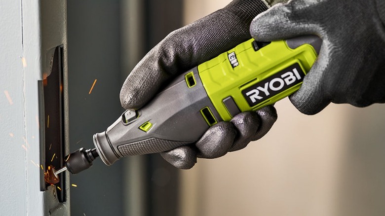 Person using Ryobi rotary tool on door