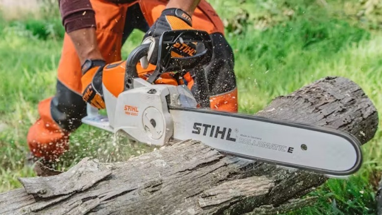 Person cutting log with Chainsaw