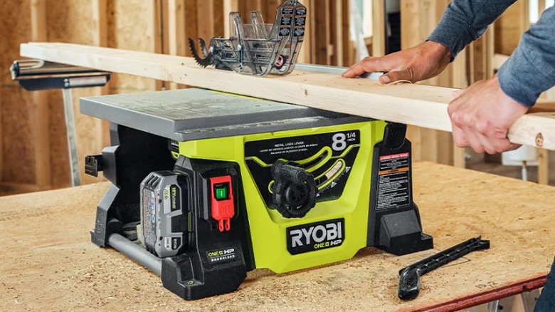Person cutting board on table saw