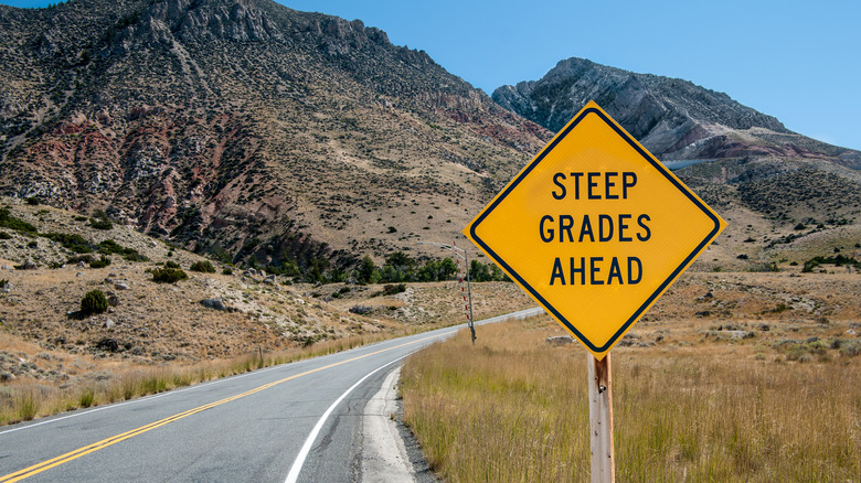 An image of a mountain road warning of steep grades