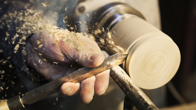 Person making cup on lathe