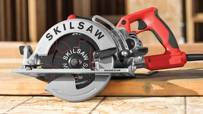 red and black Skilsaw on a piece of wood